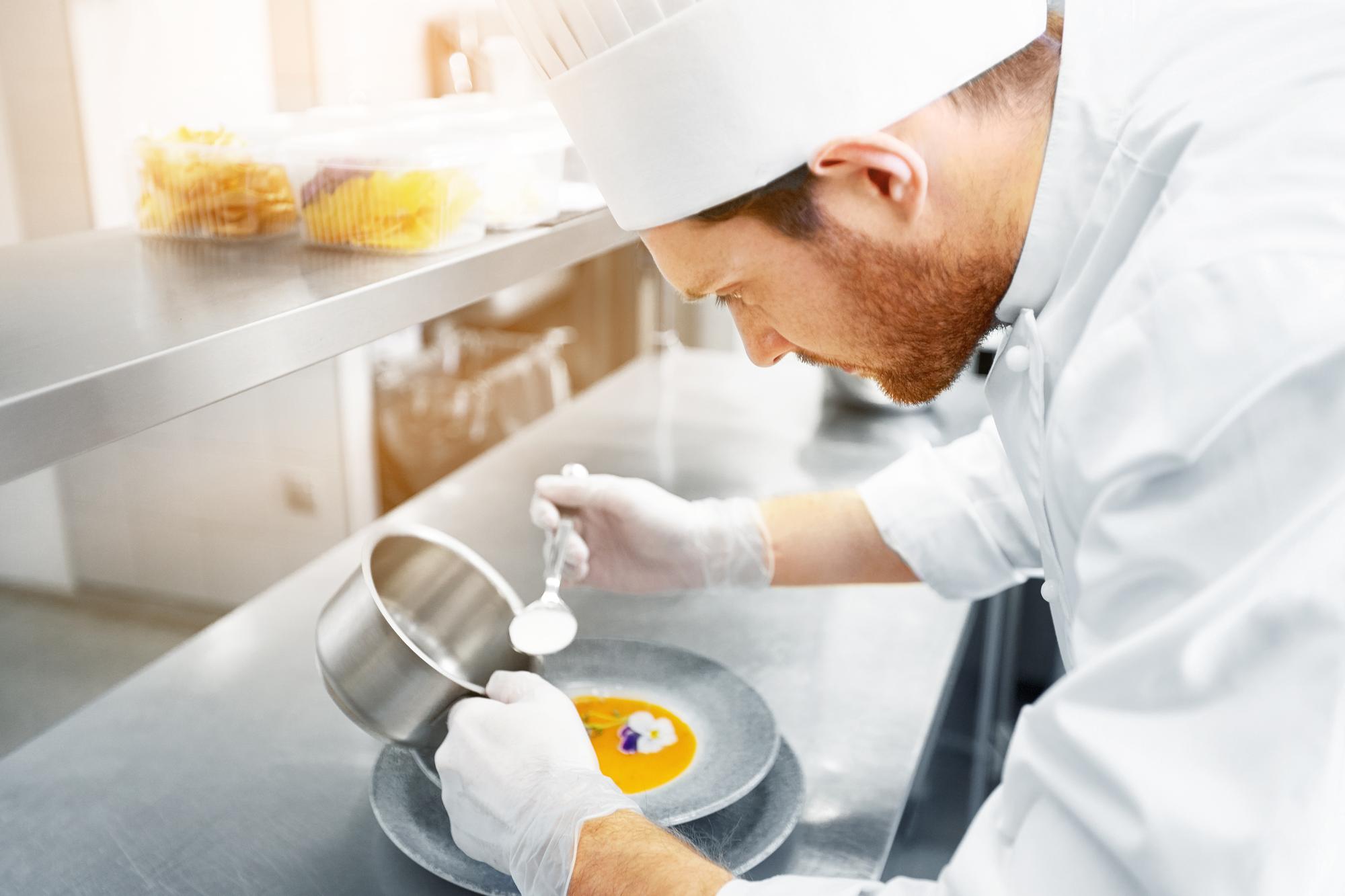szef kuchni testujący nowe danie w nowoczesnym laboratorium kuchennym